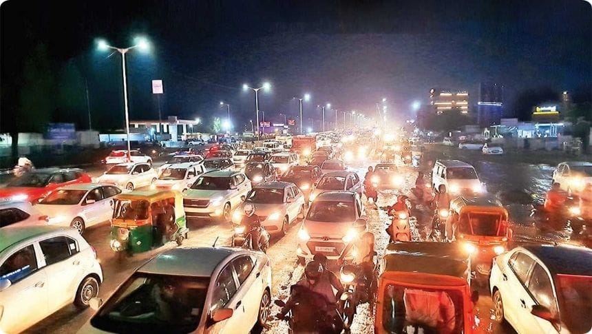 Heavy traffic jam on SG Highway Ahmedabad due to AMC road construction work causing long vehicle queues and commuter delays.